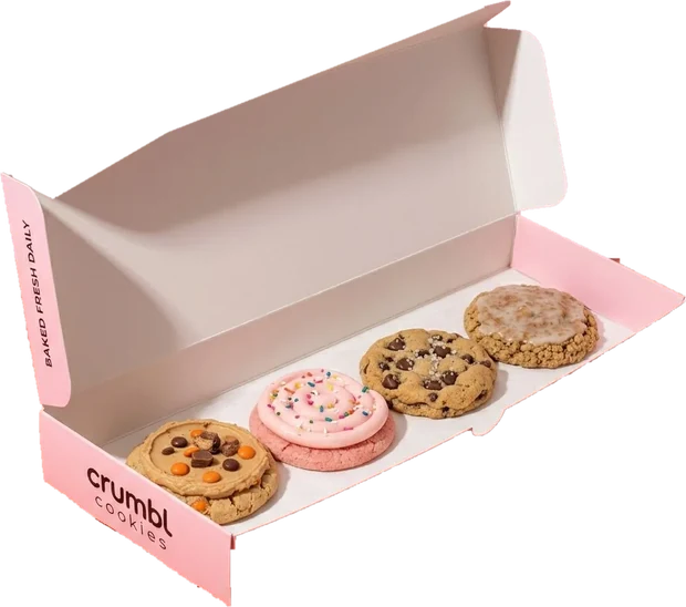 An open Crumbl cookies box holding four cookies in its paper tray