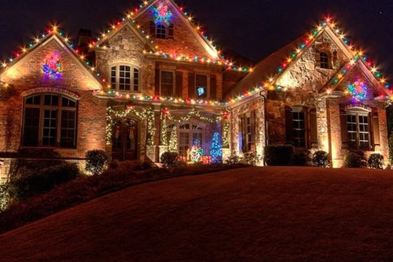 Brick home outlined in classic multicolor C9 Christmas bulbs across the rooflines, gables and front landscaping