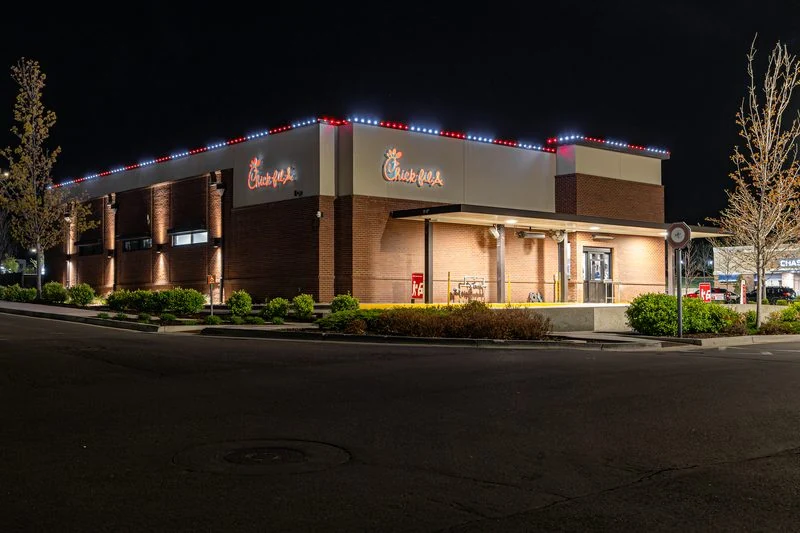 Restaurant building outlined in red and white lighting along the full roofline and entry canopy