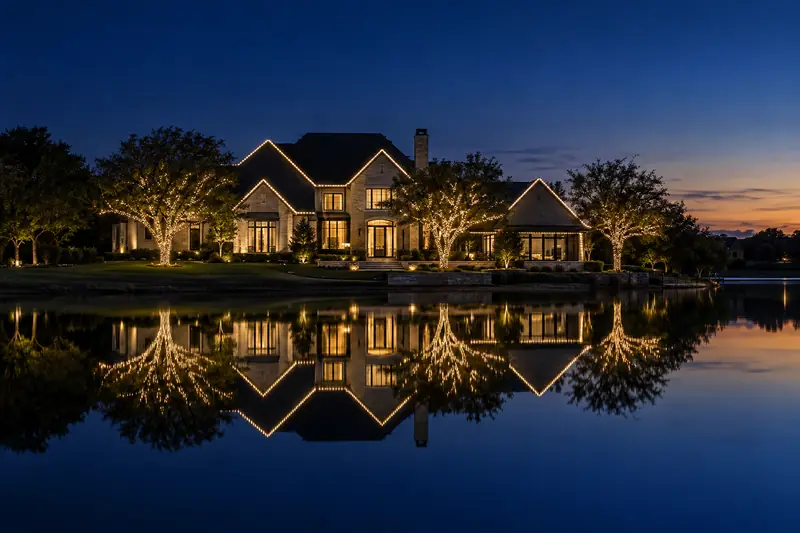 Lakeside Flower Mound TX home with holiday lighting reflected on the water at night