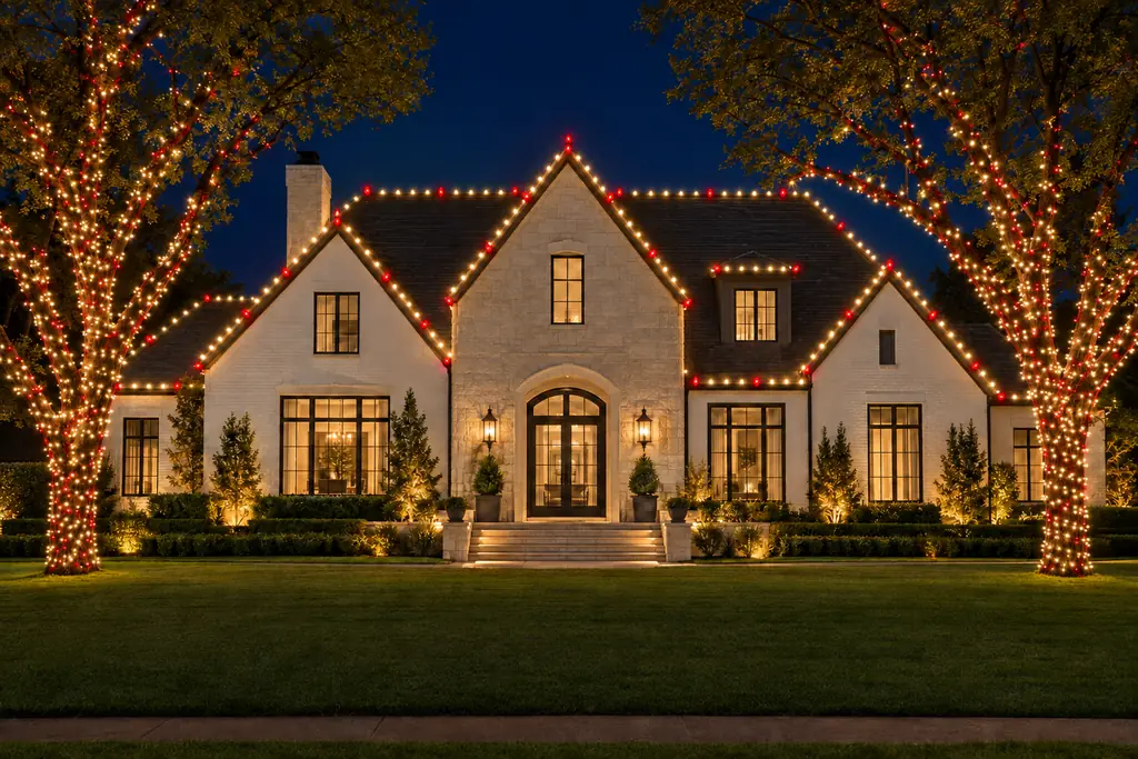 The same home shown with a custom scheme: warm white rooflines with red accent bulbs